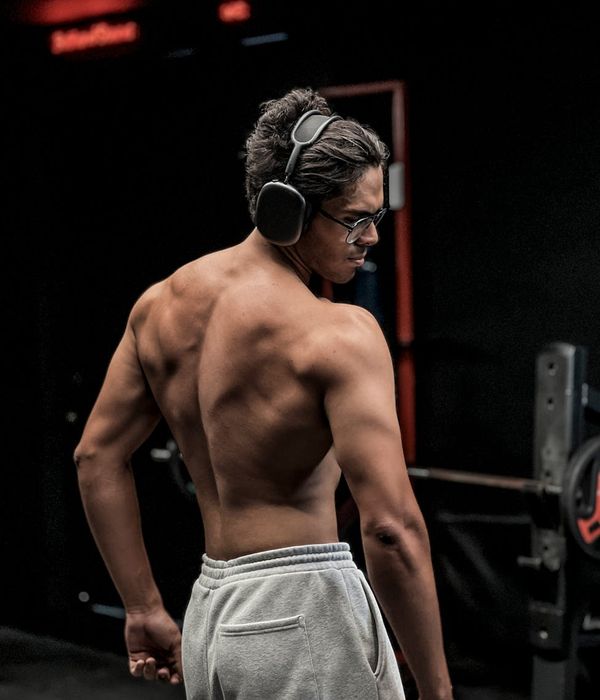 Man performing a controlled strength exercise in a dark room.